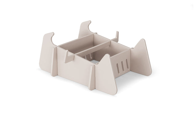 A beige, rectangular modular desk organizer with open compartments and vertical dividers, made from flat interlocking panels—perfect for organizing paperwork after a day relaxing on Ledge Lounger Signature Chaise Deep Riser.