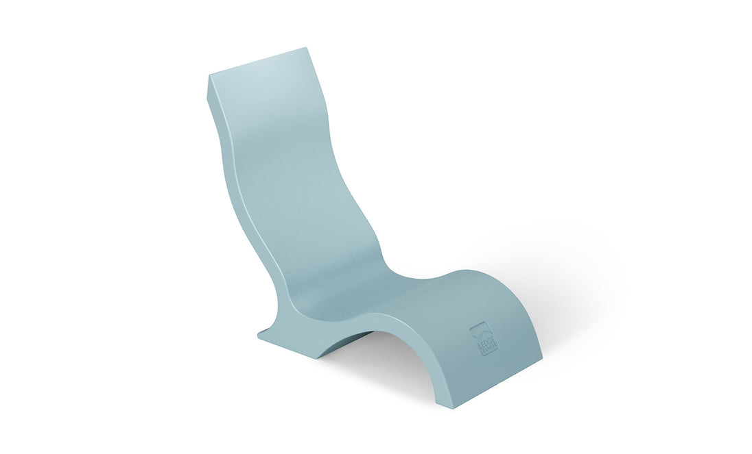 The Signature Chair by Ledge Lounger is a modern, minimalist light blue lounge chair with a sleek, curved design, perfect for outdoor oases. It features an elevated backrest and wave-like base made from smooth material, ideal as an in-pool lounger with a discreet logo on the lower section.