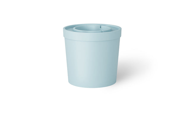 The Signature Ice Basin by Ledge Lounger is a light blue, cylindrical plastic container with a lid. The lid includes a central recessed area and a small slit for easy pouring, casting a subtle shadow on the white background.