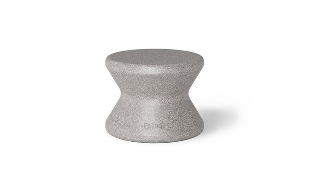 The Signature Standard Side Table by Ledge Lounger is a gray hourglass-shaped stool with a smooth surface, ideal for in-pool use. It complements any sun shelf setting and is set against a plain white background.