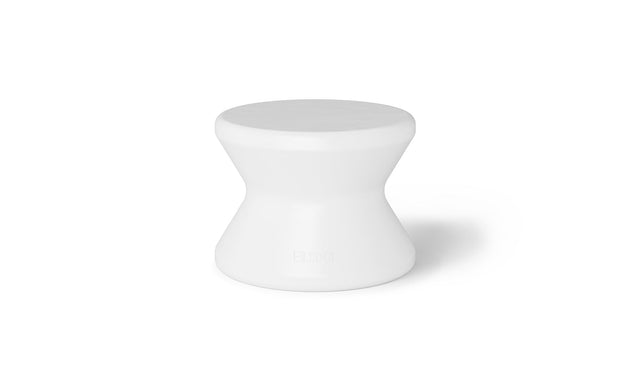 A white, hourglass-shaped stool by Ledge Lounger with a smooth surface is centered on a plain white background. Ideal for sun shelf lounging or in-pool use, it has a minimalist design with a wider base and top, narrowing in the middle—similar to the Signature Standard Side Table.