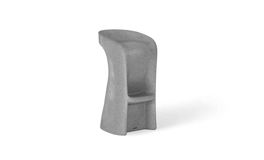 Introducing the Signature Barstool Bar Height by Ledge Lounger: a modern minimalist gray stool with a high backrest, cylindrical form, and stone-like texture. Its widened base and integrated footrest ensure support, while the curved seat is perfect for poolside seating during outdoor entertaining.