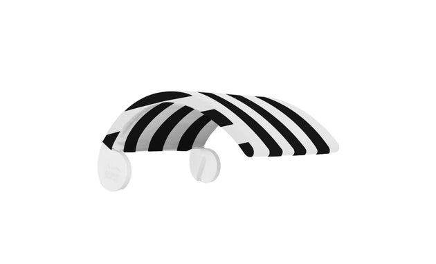 The Signature Chair Shade by Ledge Lounger is a sleek, black-and-white visor-like object with bold diagonal stripes. Its modern design features a curved shape and two circular attachments.