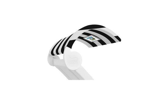 A modern, sleek desk lamp featuring a Signature Chaise Shade with black and white stripes and a small rectangular media viewing window on top. The base has Ledge Lounger in light gray letters on a plain white background.