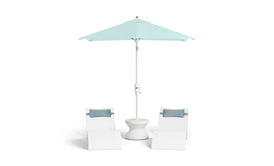 Two white lounge chairs with gray cushions surround a white round table under a 6.5 Square Signature 360° Tilt Umbrella from Ledge Lounger in light blue, featuring a rustproof frame for minimalist design and lasting outdoor relaxation.