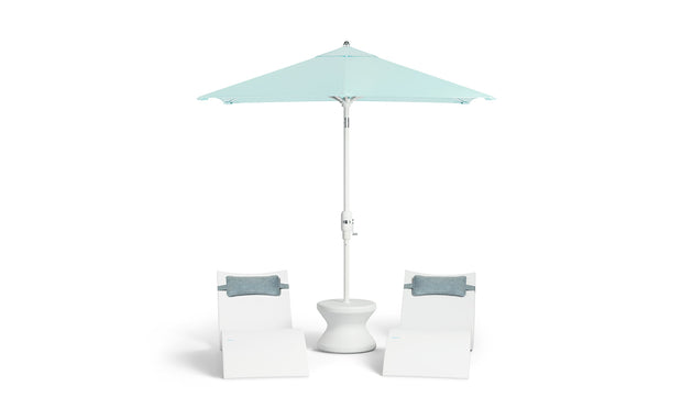 Two white lounge chairs with gray cushions surround a white round table under a 6.5 Square Signature 360° Tilt Umbrella from Ledge Lounger in light blue, featuring a rustproof frame for minimalist design and lasting outdoor relaxation.