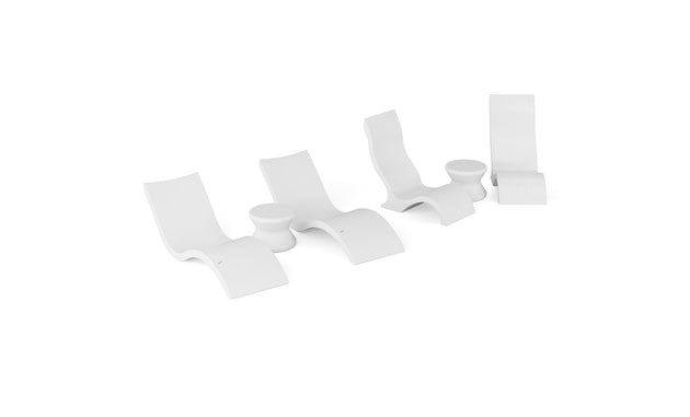 The Ledge Lounger Signature Chaise with Chairs and Side Table In-Pool 6-Piece Set features four modern white curved lounge chairs and two round tables arranged in a row, evoking resort-style poolside relaxation.