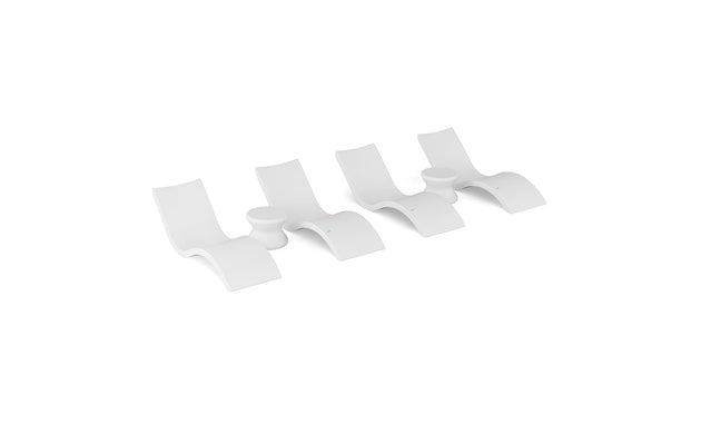 Four identical Signature Chaise and Side Table In-Pool 6-Piece Sets by Ledge Lounger, with sleek curved forms, are arranged in a row on a white background, evoking the minimalist elegance of resort poolside furniture.