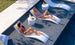 Girls smiling on in pool chaise loungers with matching headrest pillow and a side table.