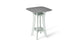 The Haven Hightop Table by Ledge Lounger is a modern square table with a grey top and light green, ergonomically curved legs. It features a small shelf below the tabletop, offering unique style and functionality as part of our patio collection.