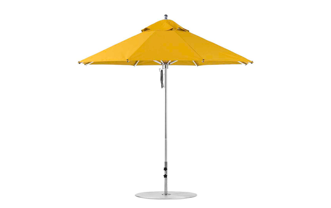 A Ledge Lounger Premier Aluminum Umbrella, featuring a yellow canopy, straight silver pole, and round base, stands open. Designed with marine-grade fabrics for durability, this 9 Octagon Pulley umbrella offers excellent shade for outdoor areas.