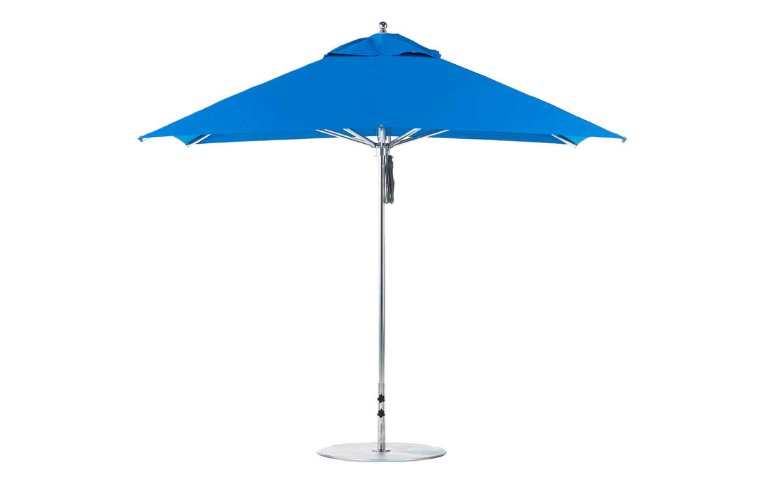 The Premier Aluminum Umbrella by Ledge Lounger features a marine-grade, wind-resistant design. This open blue 10 square umbrella stands against a white background with a sleek aluminum pole and round base, ensuring durability and style in any setting.