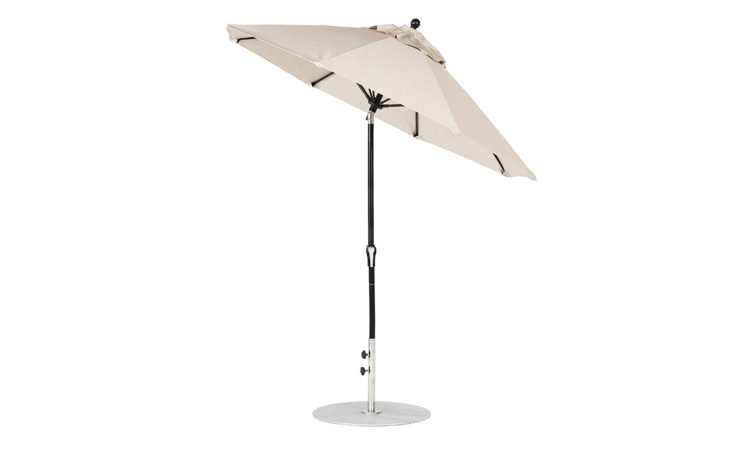 The Ledge Lounger Essential Fiberglass Umbrella, a 7.5 octagon with an auto-tilt crank, features a beige marine-grade canopy on a black pole with a round silver base, offering wind resistance and durability with side-view style.