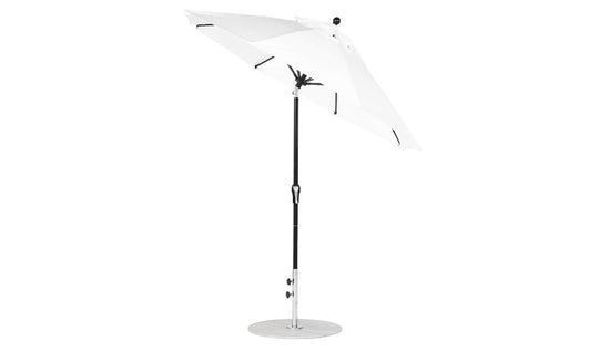 The Ledge Lounger Essential Fiberglass Umbrella - 7.5 Octagon Crank Auto Tilt features a white canopy and black pole, elegantly angled on a round base. Made with marine-grade fabrics, it offers durability and wind resistance against the white backdrop.