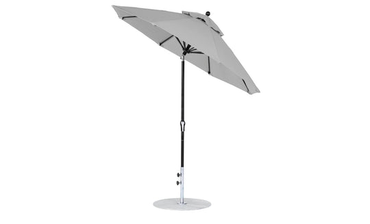 Against a plain white backdrop, the Essential Fiberglass Umbrella by Ledge Lounger, featuring a 7.5 octagon canopy in gray marine-grade fabric and a sleek black pole on a round metal base, highlights its design excellence with its partially open tilt position.