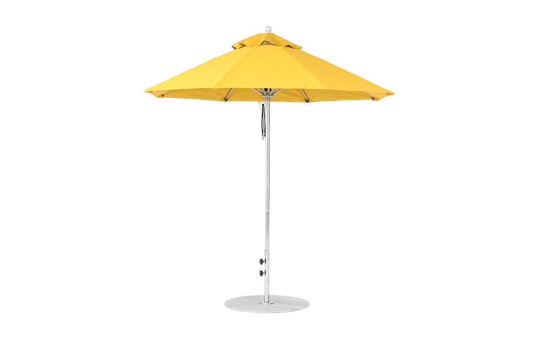 The Ledge Lounger Essential Fiberglass Umbrella - 7.5 Octagon Pulley boasts a vibrant yellow, wind-resistant marine-grade fabric with a round canopy and silver metal pole on a circular base. Fully opened, it features multiple folds, casting ample shade below.