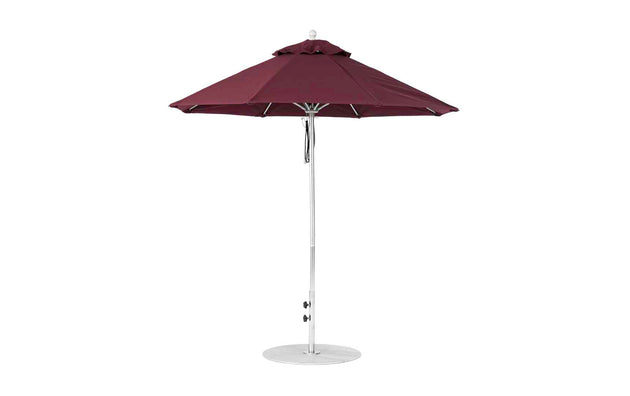 The Ledge Lounger Essential Fiberglass Umbrella - 7.5 Octagon Pulley, with a metal pole and circular base, stands upright. Featuring a wind-resistant marine-grade fabric canopy with an air vent, it ensures durability in breezy conditions.