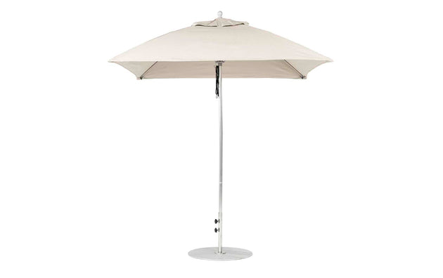 The beige Essential Fiberglass Umbrella by Ledge Lounger boasts a classic design with a 7.5 square canopy made of marine-grade fabric. It features a sleek metal pole and circular base, providing perfect outdoor shade and ensuring compatibility through the Umbrella Compatibility Matrix for versatile use.