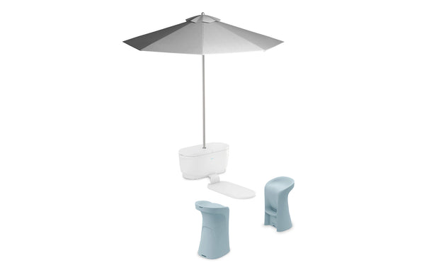 The PartyPad Swim-Up Bar by Ledge Lounger features a modern, large gray patio umbrella with base and connected footrest alongside two sleek, light blue stools, offering shade and style for a chic poolside seating area.