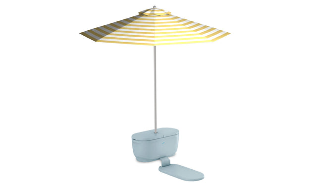 The PartyPad Swim-Up Bar by Ledge Lounger showcases a whimsical light blue toilet with a closed lid under a large yellow and white striped beach umbrella, perfect for poolside sipping. The fully open umbrella shades a flat rectangular mat extending from the toilets base.