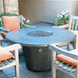 American Fyre Designs Cosmopolitan round fire table with glass top and metal frame.