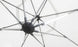 Close-up of the underside of a white umbrella with metal spokes radiating from a central hub. A Ledge Lounger Umbrella Light is attached to one spoke, creating a soft glow against the matching fabric background, ideal for an inviting patio setting.