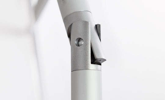 Close-up of a silver-gray metallic hinge with cylindrical components and a pivot mechanism, designed for the 7.5 Octagon Signature 360° Tilt Umbrella by Ledge Lounger, set against a plain white background.